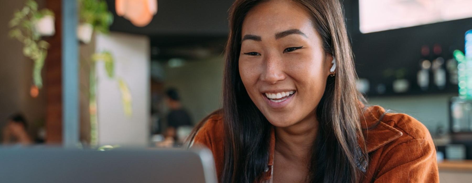 a woman smiling while working on laptop