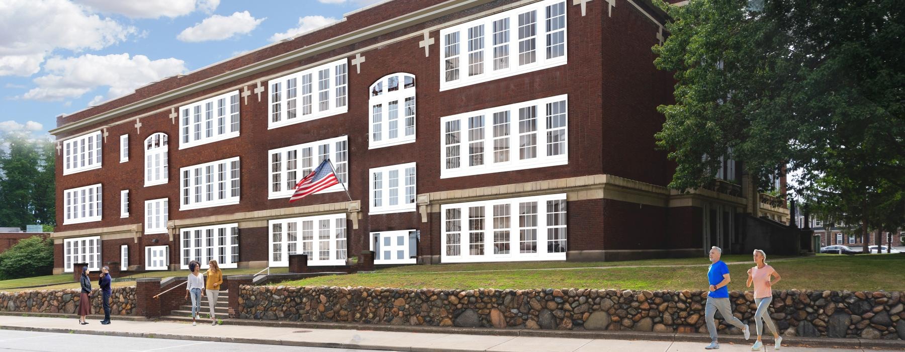 a brick building with a flag next to a sidewalk