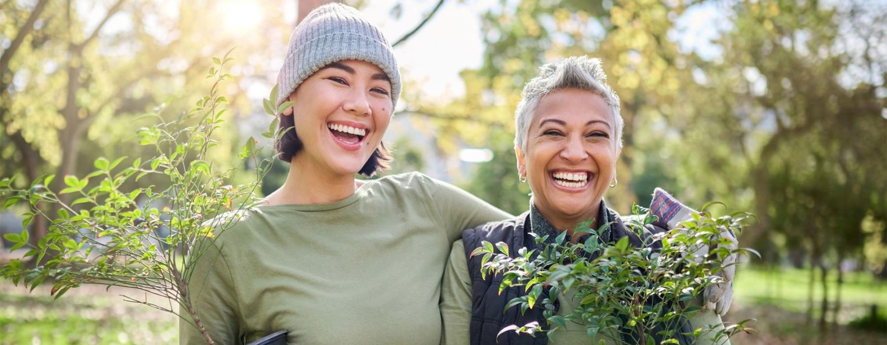 a couple of women holding plants